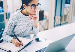 Women watching webinar and taking notes