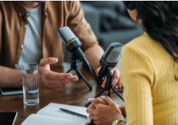 Two people recording a podcast together