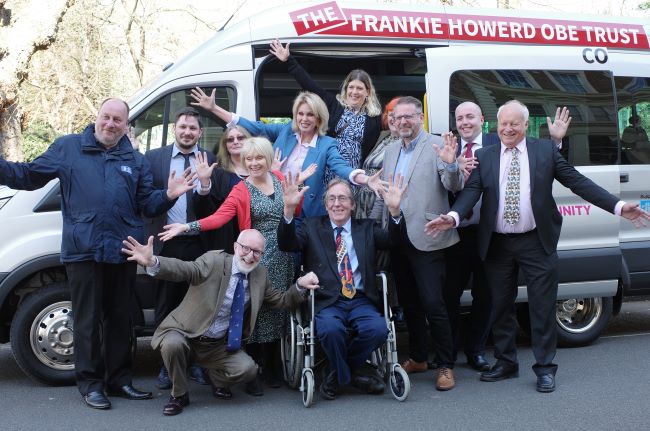 A cheque was given to residents who are posing in front of a van