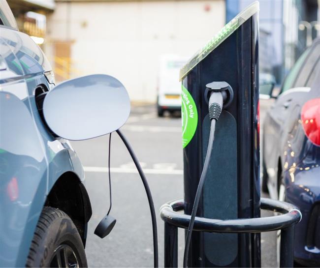 An electric vehicle charging at a charge point.